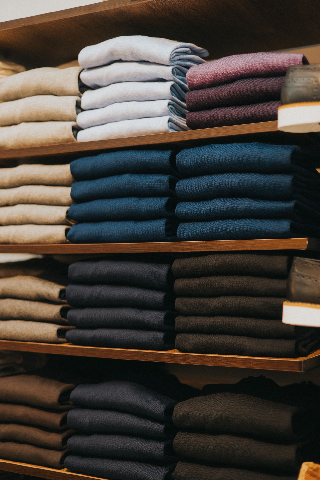 Retail store interior featuring a wall lined with shelves of denim jeans and t-shirts
